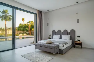 a bedroom with a large bed and a large window at Villa Alia - Piscine Chauffée - 4 BR BA - Wifi - Parking in Marrakech