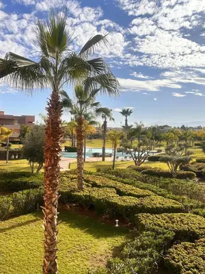 a palm tree in the middle of a park at Appartement familiale 2 chambres Prestigia in Marrakech