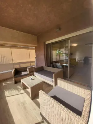 a living room with a couch and a table at Appartement familiale 2 chambres Prestigia in Marrakech