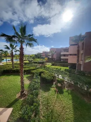 a palm tree in the middle of a park at Appartement familiale 2 chambres Prestigia in Marrakech