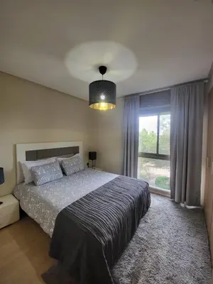a bedroom with a bed and a large window at Appartement familiale 2 chambres Prestigia in Marrakech