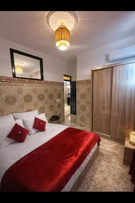 a bedroom with a large bed with a red blanket at 2 bedroom apartment in heart of Madina in Marrakech