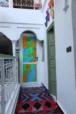 a colorful hallway with a door with a mosaic floor at Riad dar lfen in Marrakech