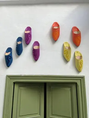 a group of different colored clippers on a wall above a door at Riad dar lfen in Marrakech