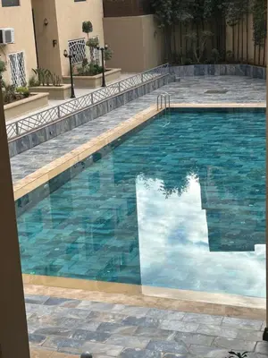 a swimming pool with blue water in a building at malak g7 in Marrakech