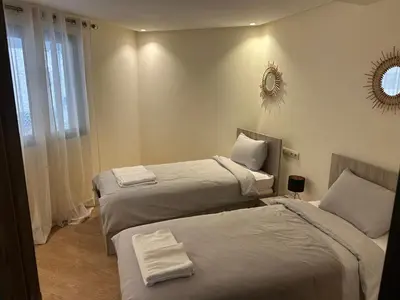 a hotel room with two beds and a mirror at malak g7 in Marrakech