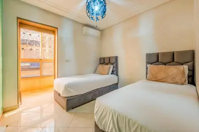 a bedroom with two beds and a window at Logement entier Appartement Cosy - Marrakech in Marrakech