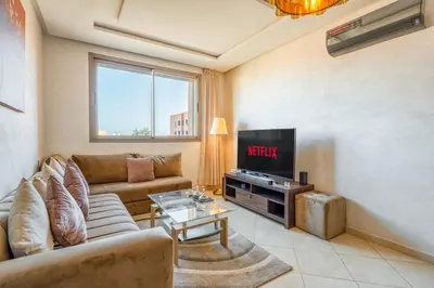a living room with a couch and a tv at Logement entier Appartement Cosy - Marrakech in Marrakech