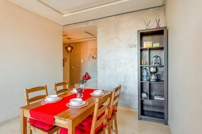 a dining room with a red table and chairs at Logement entier Appartement Cosy - Marrakech in Marrakech
