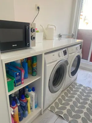 a kitchen with a washing machine and a microwave at Appartement luxe in Marrakech