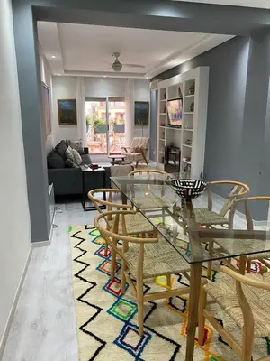 a living room with a glass table and chairs at Appartement luxe in Marrakech