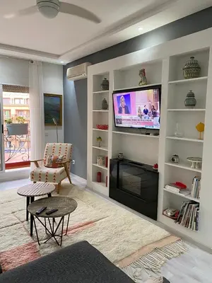 a living room with a flat screen tv on a wall at Appartement luxe in Marrakech