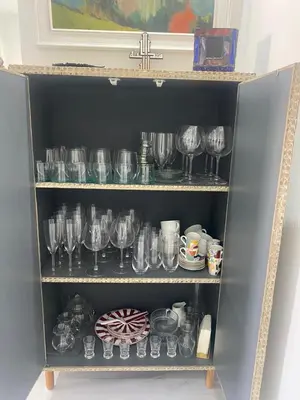 a shelf full of wine glasses and other items at Appartement luxe in Marrakech