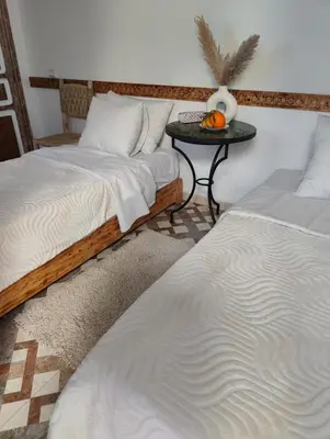 a room with two beds and a table with a pumpkin at Dar Manzakin in Marrakech