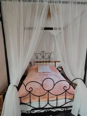 a bedroom with a canopy bed with white curtains at Dar Manzakin in Marrakech