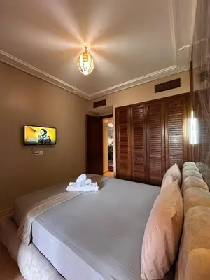 a bedroom with a large bed and a couch at Marrakech Oasis, Residence Ennaim in Marrakech