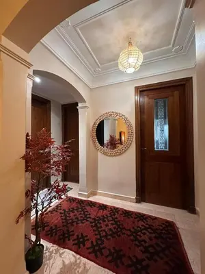 a hallway with a door and a rug and a mirror at Marrakech Oasis, Residence Ennaim in Marrakech