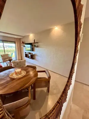 a living room with a round table and a couch at Appartement RDJ - Golf - Piscine - restaurants in Marrakech