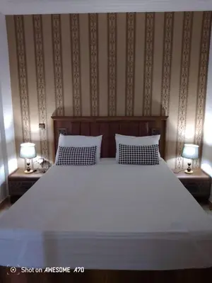 a bedroom with a large white bed with two lamps at Charming Two-Bedroom Apartment in Gueliz,Marrakesh in Marrakech