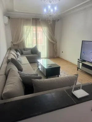a living room with a large couch and a television at Charming Two-Bedroom Apartment in Gueliz,Marrakesh in Marrakech