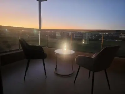 a room with two chairs and a table with a candle at Prestigia Luxury Golf-View Escape in Marrakech