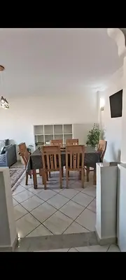 a living room with a wooden table and chairs at Cute affordable apartment in Marrakech
