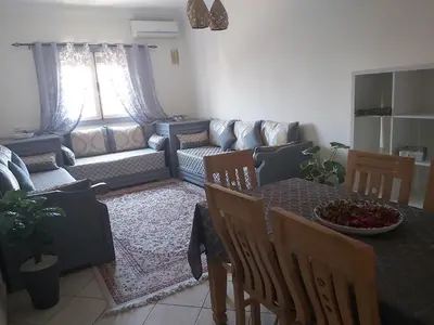 a living room with a table and a couch at Cute affordable apartment in Marrakech