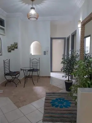 a room with a table and chairs and a potted plant at Cute affordable apartment in Marrakech