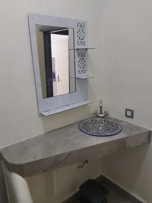 a bathroom with a stone sink and a mirror at Cute affordable apartment in Marrakech
