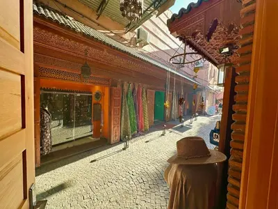 a person wearing a hat sitting on a street at Dar Safary in Marrakech