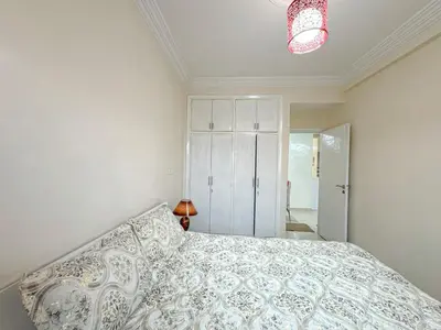 a bedroom with a bed with a white comforter at 1BR Chic à Izdihar Clim, Wi-Fi & Cuisine Équipée in Marrakech