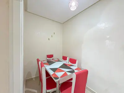 a table with four red chairs in a room at 1BR Chic à Izdihar Clim, Wi-Fi & Cuisine Équipée in Marrakech