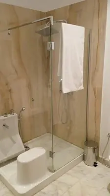 a bathroom with a glass shower with a toilet at villa du golf in Marrakech