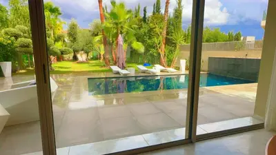 a view of a swimming pool through a window at villa du golf in Marrakech