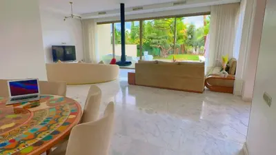 a living room with a table and chairs and a couch at villa du golf in Marrakech