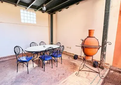 a room with a table and chairs and a large vase at Charming townhouse in Marrakech in Marrakech