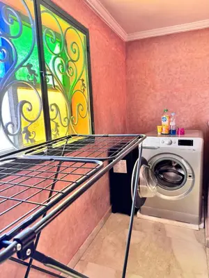 a laundry room with a washing machine and a painting at Charming townhouse in Marrakech in Marrakech