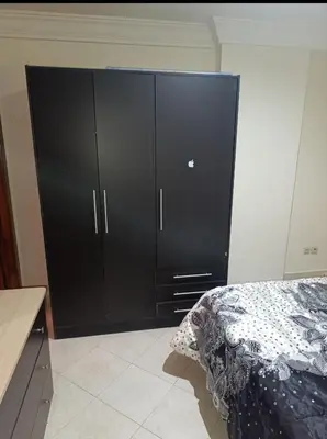 a large black cabinet in a bedroom with a bed at Magnifique appartement in Marrakech