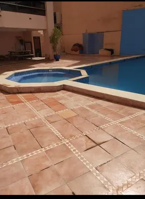 a swimming pool with a tiled floor and a pool at Magnifique appartement in Marrakech