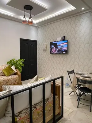 a living room with a couch and a tv on a wall at Apartment in Marrakesh in Marrakech