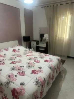 a bedroom with a bed with a floral comforter at Appartement Layane 2 chambres 8 mn de gueliz in Marrakech
