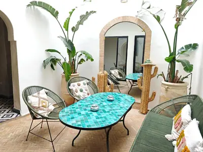 a room with a table and chairs and a mirror at Riad Choubi 3 Bedroom Medina in Marrakech