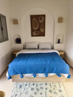 a bedroom with a bed with a blue blanket at Riad Choubi 3 Bedroom Medina in Marrakech