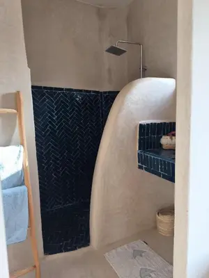 a bathroom with a shower with a blue tiled wall at Riad Choubi 3 Bedroom Medina in Marrakech
