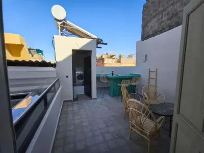 a patio with a table and chairs on a balcony at Riad Choubi 3 Bedroom Medina in Marrakech