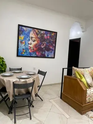 a dining room with a table and a painting on the wall at شقة سكنية للايجار بمراكش in Marrakech