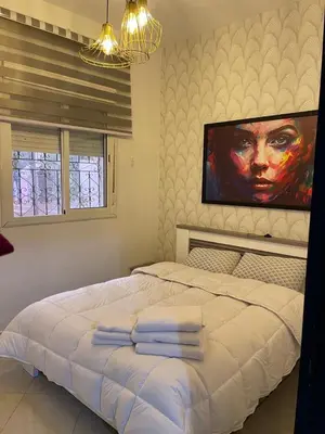 a bedroom with a large white bed with towels on it at شقة سكنية للايجار بمراكش in Marrakech