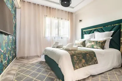 a bedroom with a large bed with a green headboard at Résidence Miramas Gueliz in Marrakech