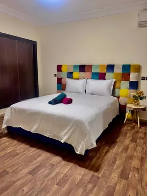 a bedroom with a large white bed with a colorful headboard at Résidence Miramas Gueliz in Marrakech