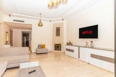 a living room with a couch and a tv on a wall at Marrakech Private Pool Villa in Marrakech